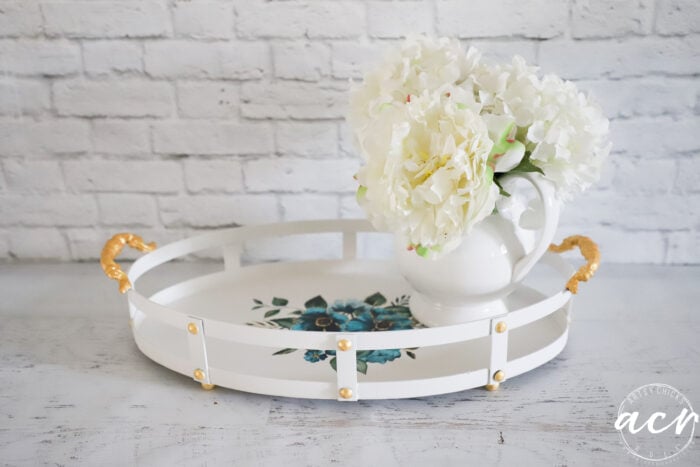 white tray with gold accents and blue transfer with white vase and white flowers