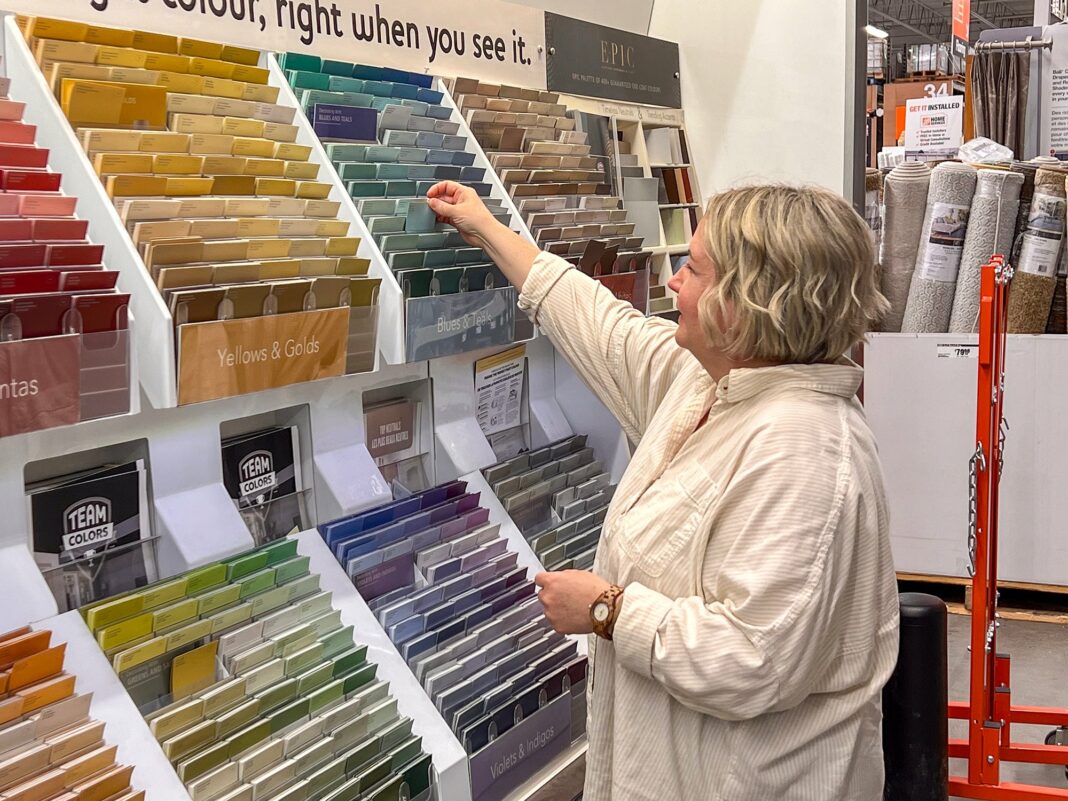 woman looking at paint swatches in store